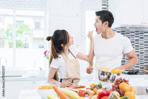 Asian Lovers feeding fruit and food to each other, Couple and Family concept. Honeymoon and Holidays theme. Indoor interior