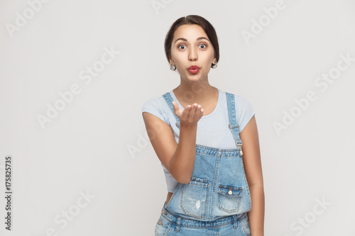 Foto Young adult gypsy girl, posing over gray background , looking at camera and sending kisses