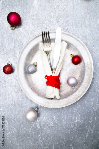 Christmas table place setting. Holidays background. Silver plate, knife and fork with christmas decorations. Top view.