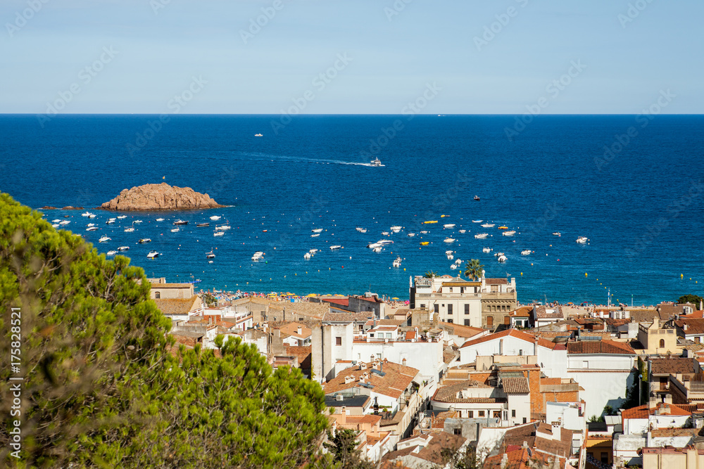 Fototapeta premium Top view of the town of Tossa de mar, city on the Costa Brava. Buildings and hotels by the beach. Amazing city in Girona, sea and moored boats in Catalonia. City and see.