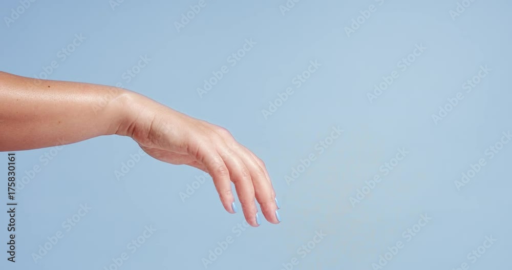 Clean well manicured hands of a young woman, applying hand cream, skin care on light blue background Clean well manicured hands of a young woman, applying hand cream, skin care on light blue background