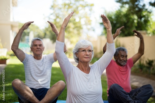 Senior people exercising with arms raised © WavebreakMediaMicro