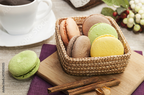 French cookies on a wooden table and coffee in a white mug, macaroons