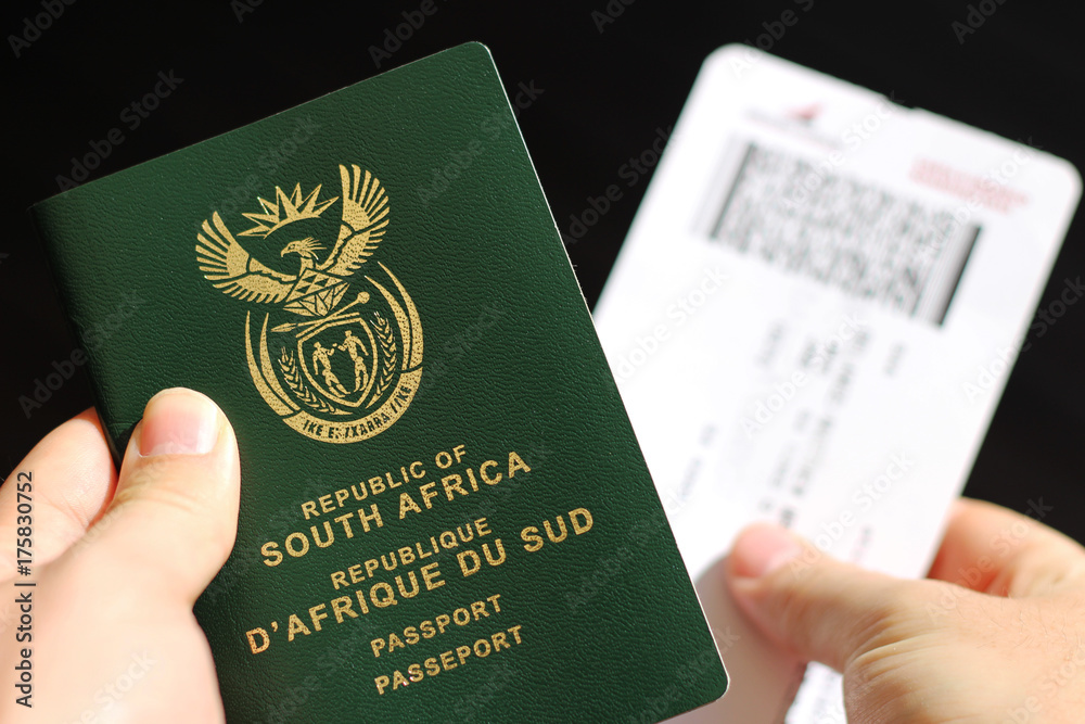 Hands Holding A South African Passport And A Plane Ticket This Image 