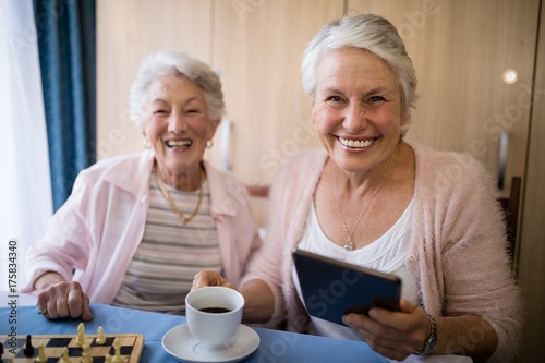 Portrait of smiling senior friends having coffee while playing
