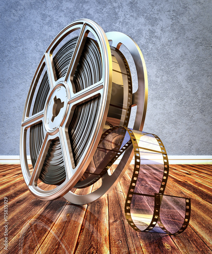 Video and multimedia concept, vintage film reel with filmstrip on wood floor