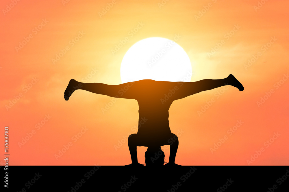 Silhouette of a beautiful Yoga woman with sun background 