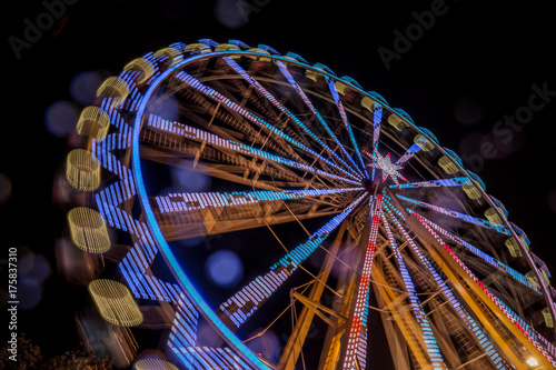 Ferris wheel at night with a motion blur and lens flares at the christmas market