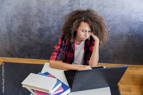 Εκτύπωση καμβά Unhappy teenage girl using laptop at h ome