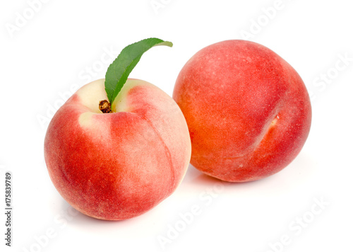 Two peaches with green leaf isolated on white background