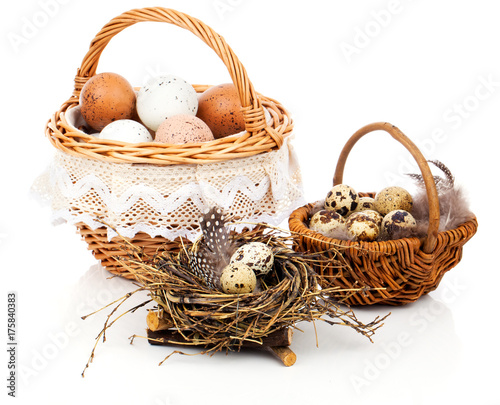 basket with eggs and quail eggs on a white background