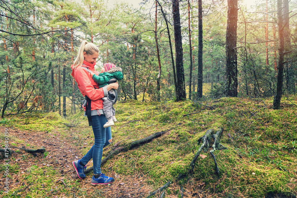 mother walking in the woods with baby in kangaroo bag