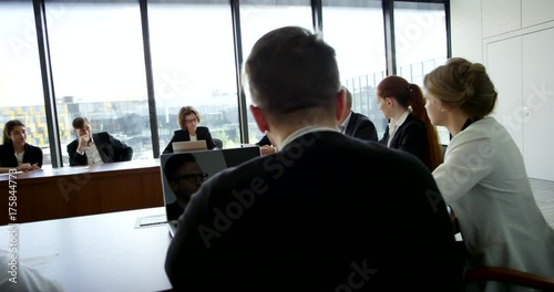 Business People at corporate meeting sitting around table and talking