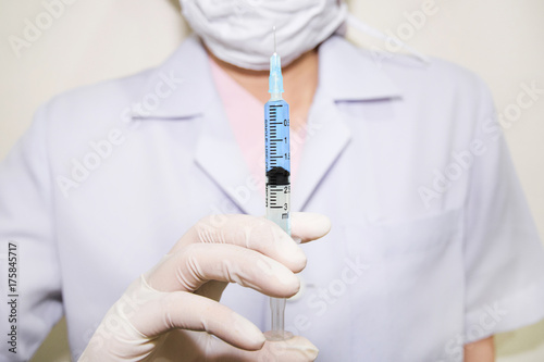 close up of doctor holding syringe with injection