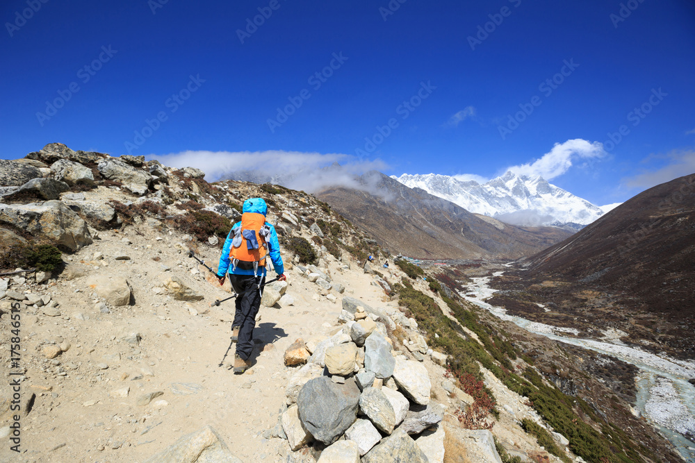 young woman backpacker trekking on himalaya mountains,drying socks on the backpack