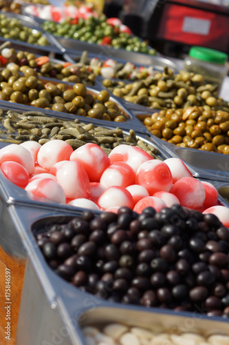 Different types of olives and pickled onions are on display in the market in Spain