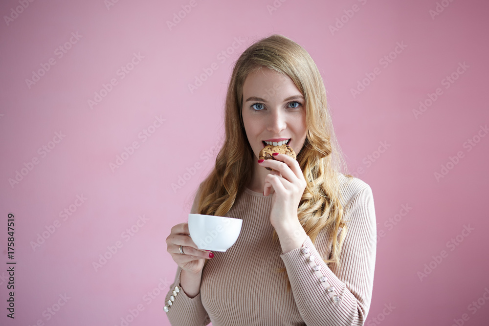 Φωτογραφία Charming young Caucasian female in casual clothes enjoying delicious homemade cookie and coffee