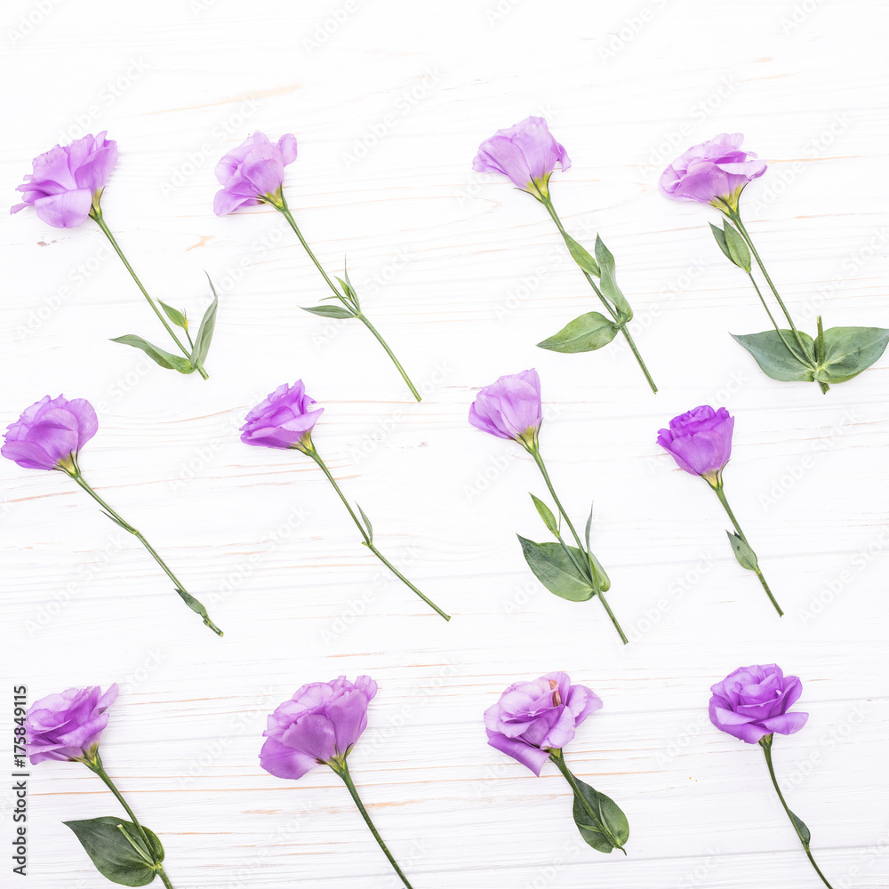 Flowers composition. Frame made Colorful eustoma flowers on white wooden background and free space for text at the top Flowers composition. Frame made Colorful eustoma flowers on white wooden background and free space for text at the top