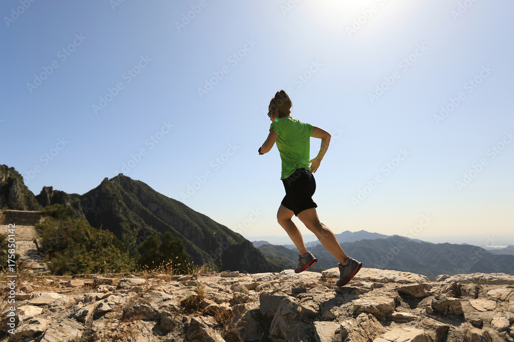 young fitness woman trail runner running on top of mountain young fitness woman trail runner running on top of mountain