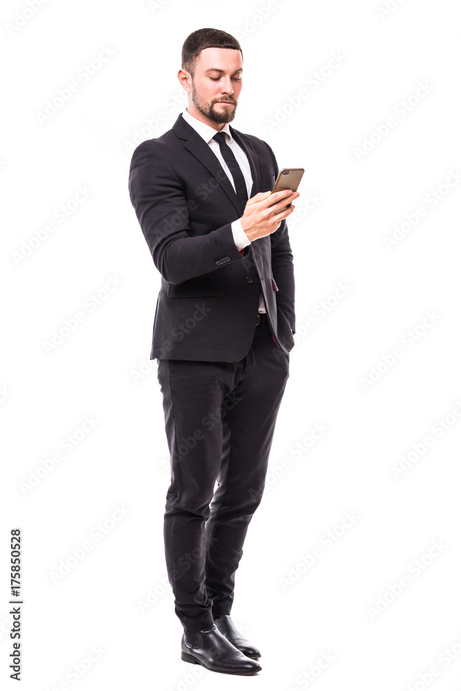 Young bearded business man typing message on smartphone touch screen. Full body length portrait isolated over white studio background. Young bearded business man typing message on smartphone touch screen. Full body length portrait isolated over white studio background.