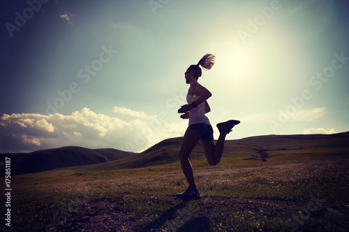 Fototapeta Naklejka Na Ścianę i Meble -  young fitness woman runner running on grassland trail