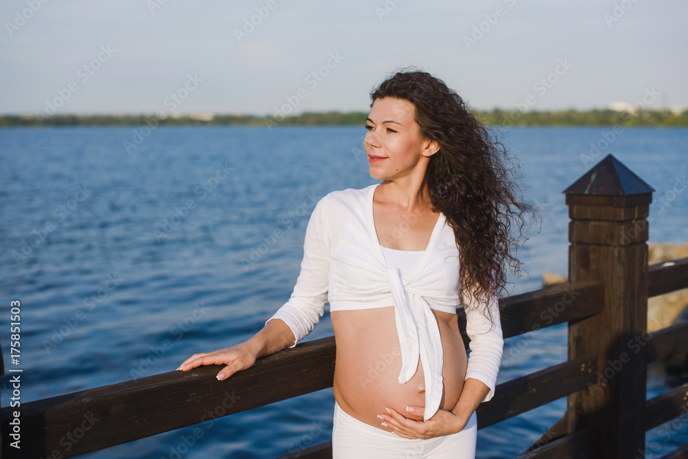 Young pregnant woman  by the river