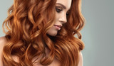 Beautiful model girl with long red curly hair .Red head . Care and beauty hair products 