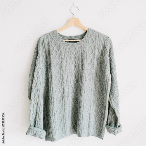 Women's fashion clothes concept. Female styled look with warm sweater on hanger. photo