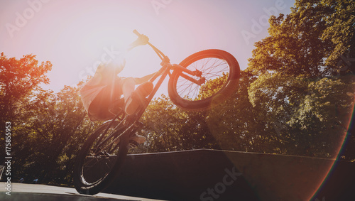 Bmx rider performing tricks at skatepark.