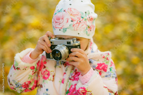 Little girl taking picture using vintage film camera