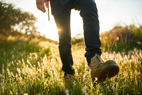 close up of hikers boot while walking through grass during hike