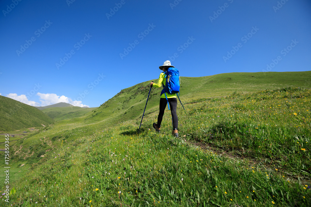 backpacking woman hiking on prairie mountain trail