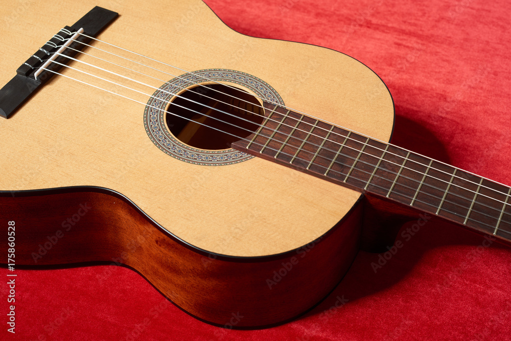 acoustic guitar on red velvet fabric, closeup object acoustic guitar on red velvet fabric, closeup object