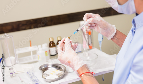 Doctor with syringe in hand. Medical health professional holding a vaccine injection. Concept of vaccination against flu and Viral Diseases.