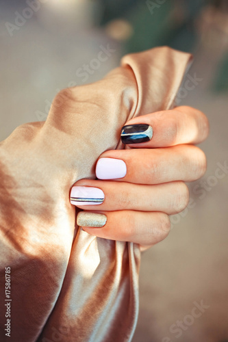 Multi-colored manicure against the background of gold silk