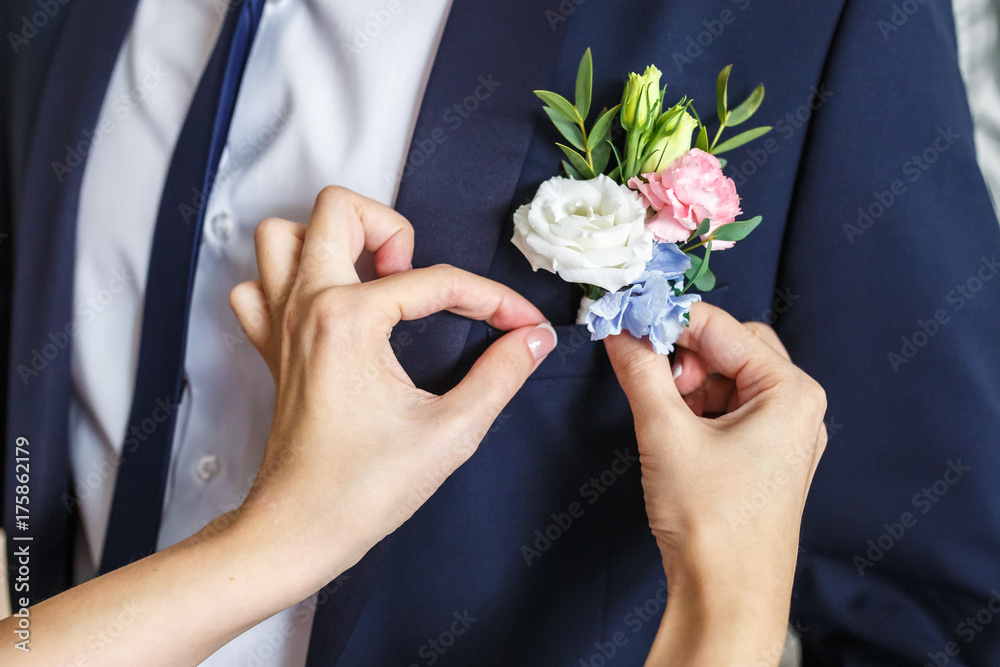 Bride corrects groom boutonniere at their wedding Bride corrects groom boutonniere at their wedding