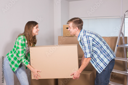 Happy young couple unpacking or packing boxes and moving into a new home.