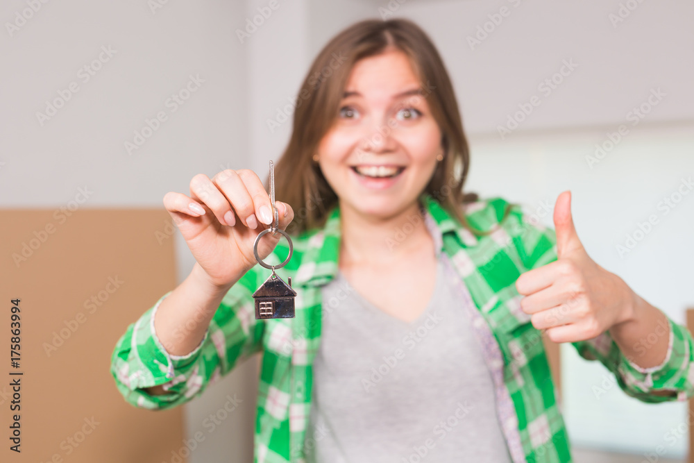 Happy apartment owner or renter showing keys and making thumbs up gesture Happy apartment owner or renter showing keys and making thumbs up gesture