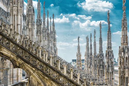 Milan Cathedral rooftop, beautiful ornate Gothic roof on sky background, Italy