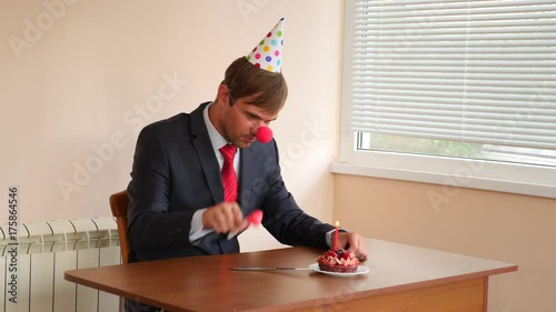 a lone man celebrates a holiday, he sits alone at a table with a cake and a candle. 4k, slow motion photo