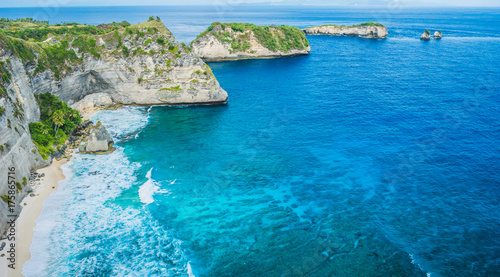 Rock in the ocean with beautiful palms behind at Atuh beach on Nusa Penida island, Indonesia