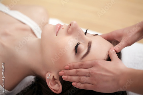 Spa relaxation, skincare, healthy pleasure concept. Woman lying with closed eyes having relaxing face massage