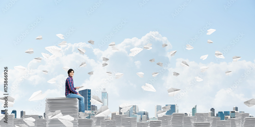 Attractive man sitting on pile of paper documents. Attractive man sitting on pile of paper documents.