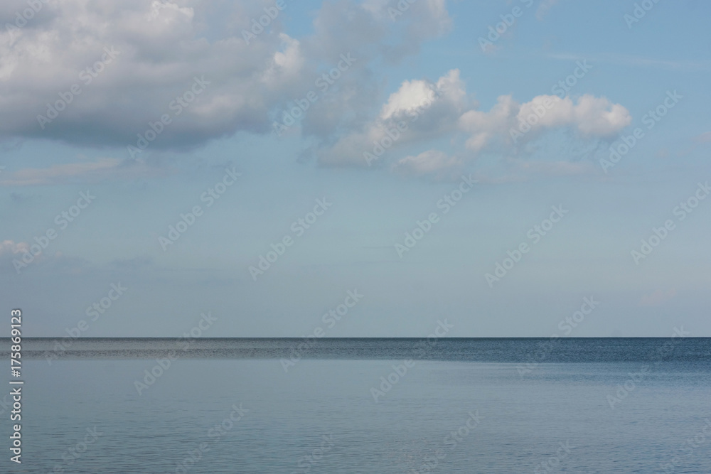 horizon separating  water surface and clouds sky