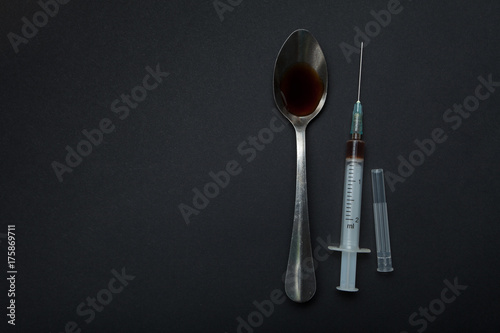 Prepared heroin in a spoon and a syringe. Space for text.