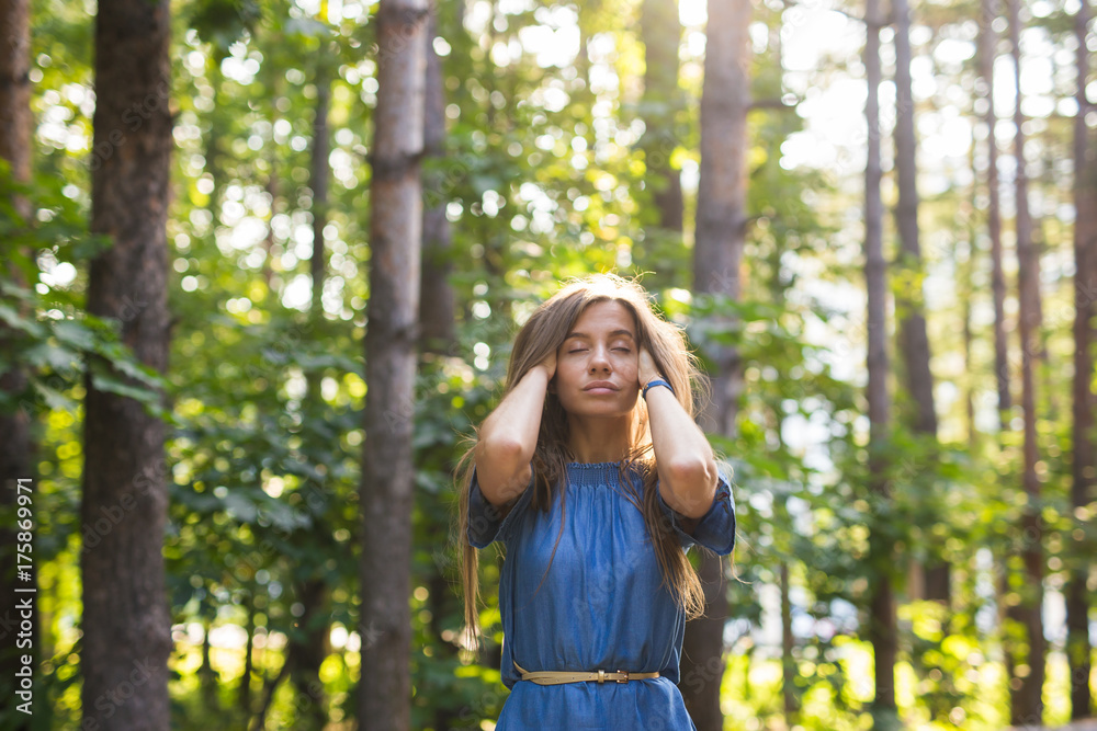 Nature, people and summer concept - Portrait of young woman enjoying the green forest. Nature, people and summer concept - Portrait of young woman enjoying the green forest.
