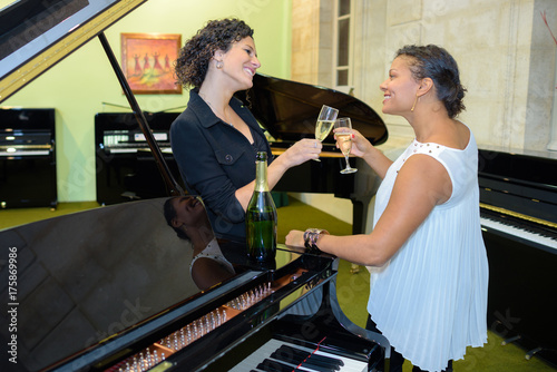 Women by piano toasting with champagne