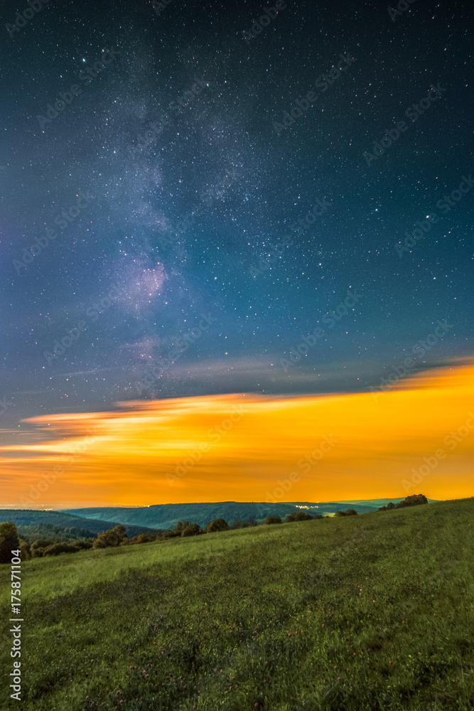 Landscape with the Milky Way as seen from the mountain Katzenbuckel in the Odenwald in Germany.