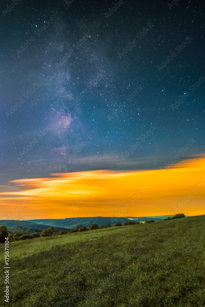 Obraz premium Landscape with the Milky Way as seen from the mountain Katzenbuckel in the Odenwald in Germany.