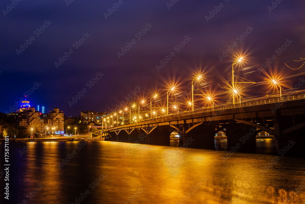 Beautiful illuminated Chernavskiy Bridge through Voronezh river at night